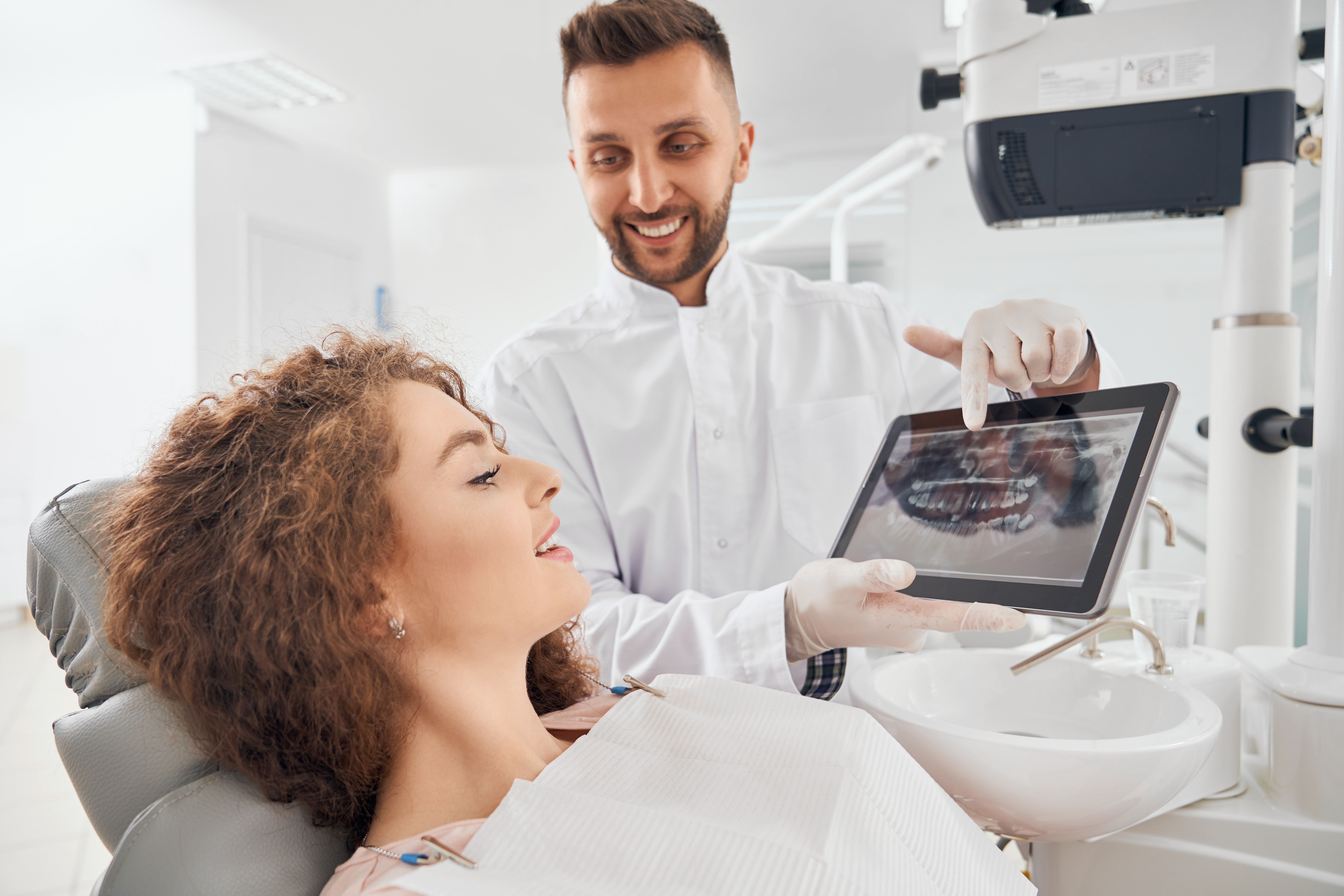 Dentist showing X-ray pictures of teeth on a tablet